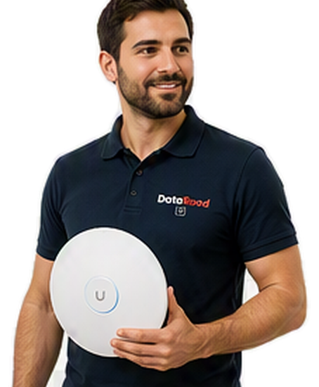 Homme barbu portant un polo bleu marine tenant un appareil sans fil blanc et rond avec un anneau bleu et un bouton ' U ', portant un polo avec le logo DotaRoad.