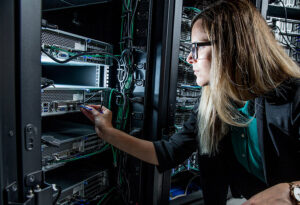 Una técnica informática conecta un cable de red a un servidor montado en un rack en un centro de datos.